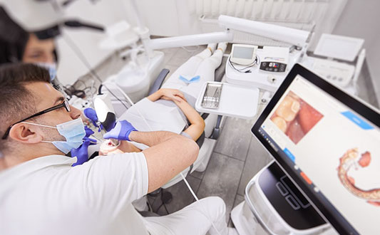 Dentist performing oral examination on patient using dental tools in modern clinic setting.