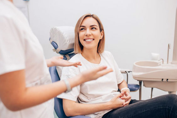 Female patient receiving dental examination from dentist in clinical setting at Fremont Dental Group.