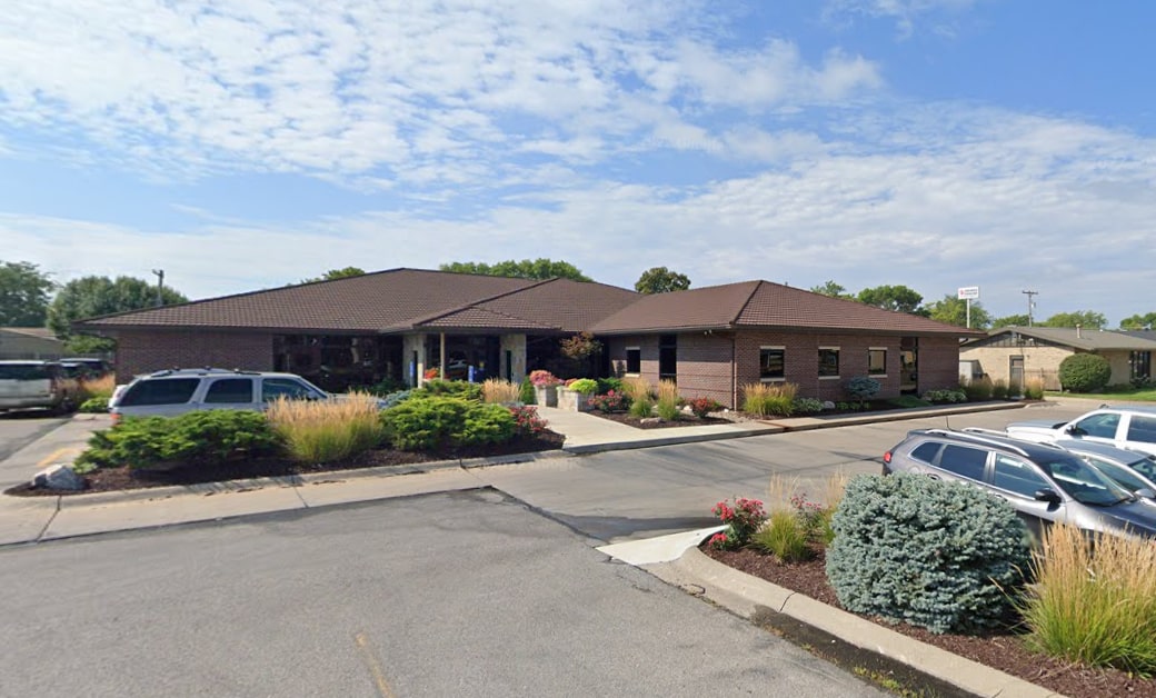 Fremont Dental Group's brick dental office building with parking lot and landscaping on sunny day.