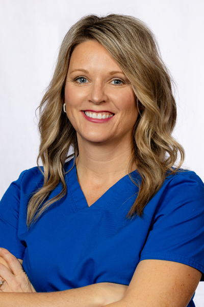 Professional portrait of woman in blue scrubs smiling at dental office