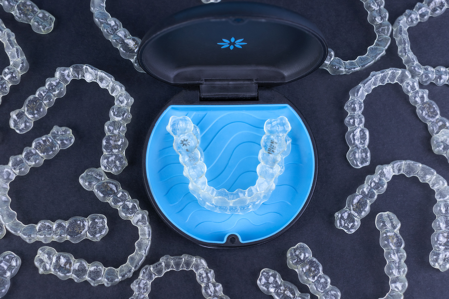 CT scan showing upper dental arch with bright blue 3D reconstruction of teeth and jaw structure.