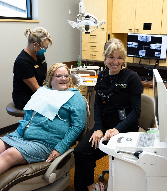 Dental hygienist assists young patient in examination chair at Fremont Dental Group office.